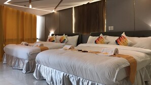 Ett modernt hotellrum med två queen size-sängar, ett stort fönster och en modern takdesign.