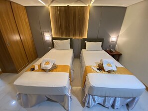 Habitación superior con 2 camas individuales | Espacio para trabajar con laptop y ropa de cama 
