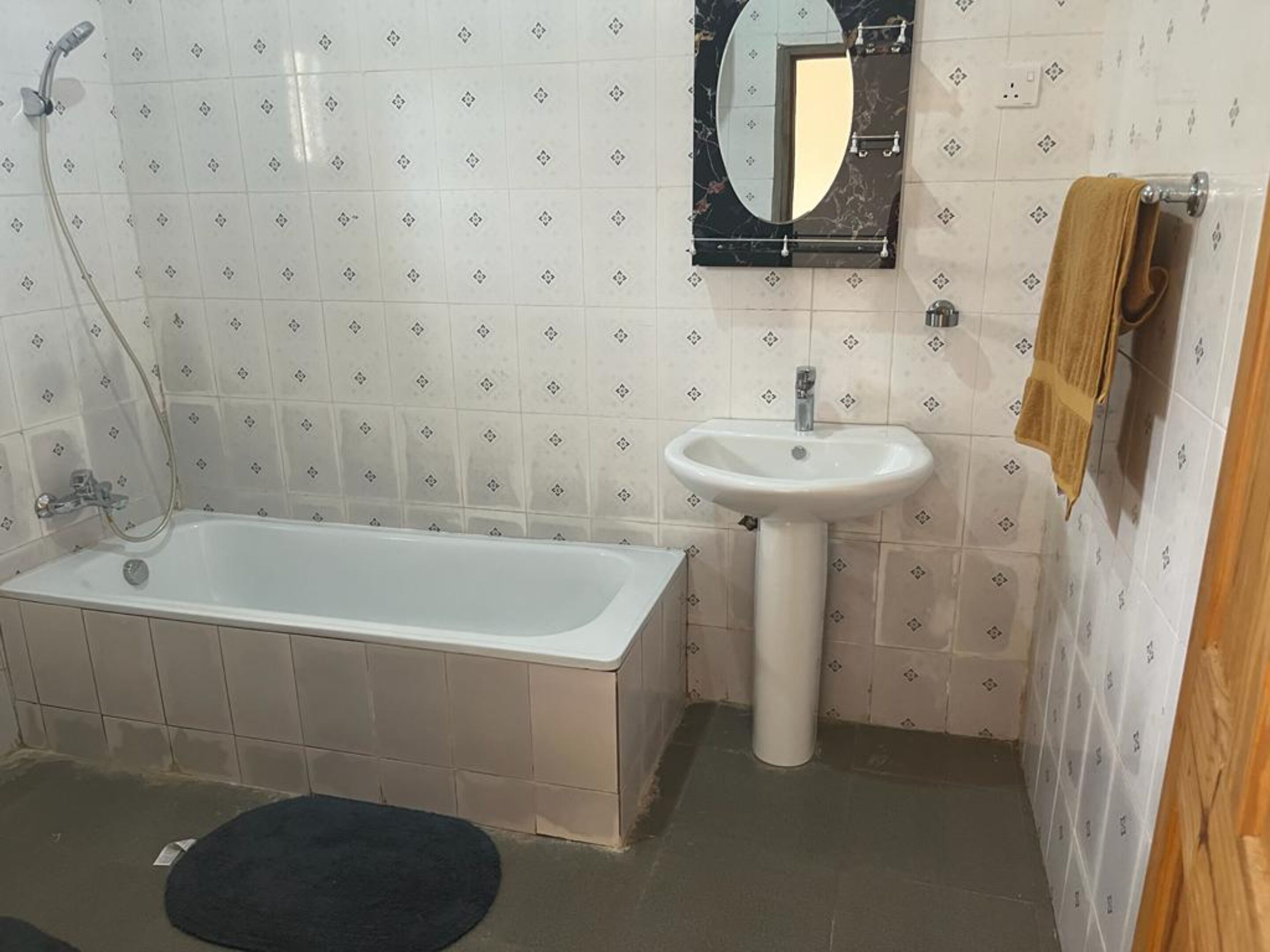 A bathroom with a bathtub, a sink, and a mirror.