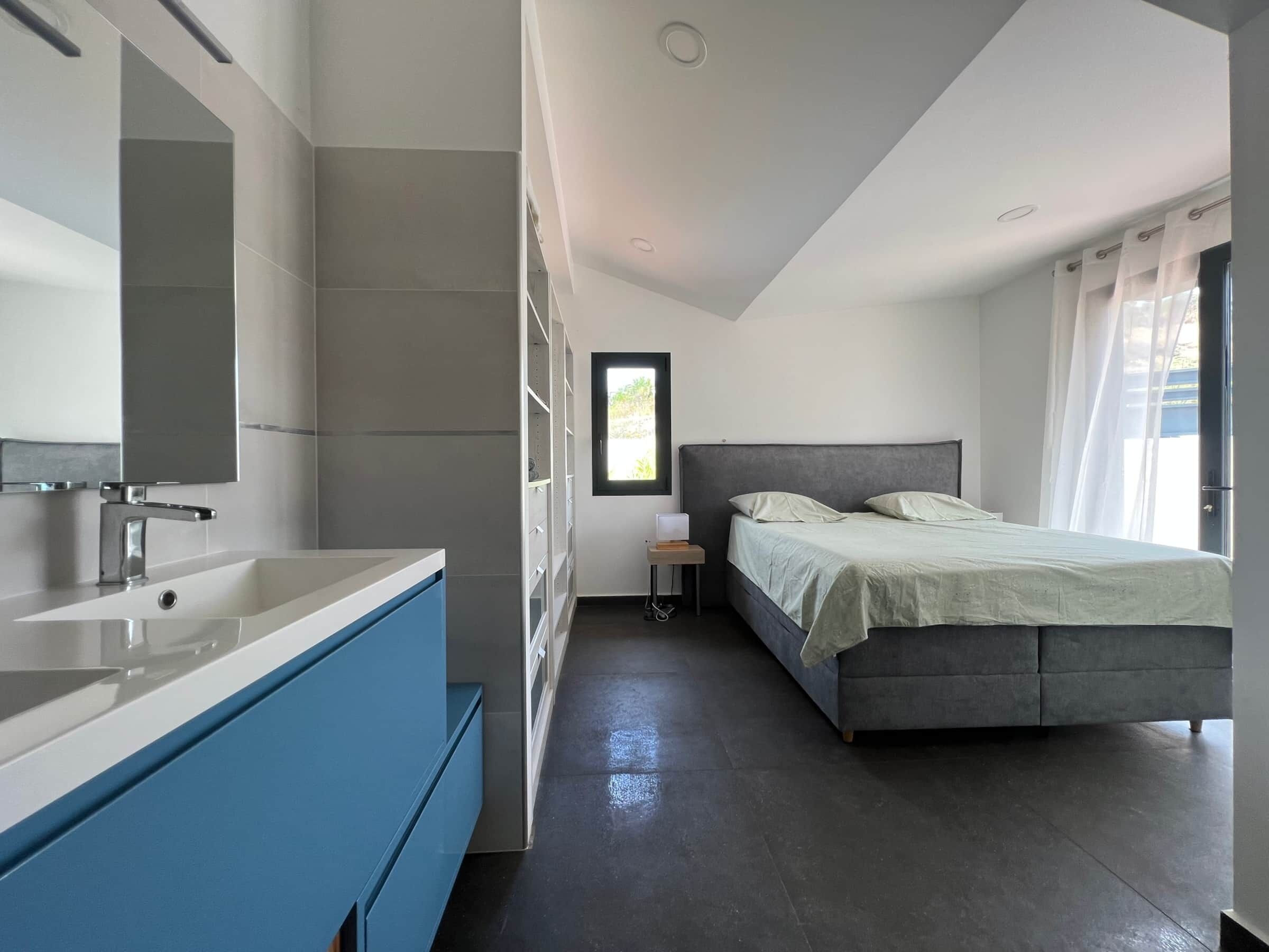 Un dormitorio moderno con una cama grande, una mesita de noche y una ventana con cortinas.