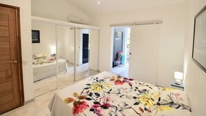 Un dormitorio con cama, armario y espejo.