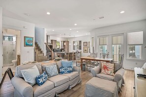 Relax in this inviting living area with a large sofa, dining table, and kitchen.