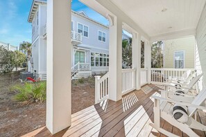 Relax on the covered porch with a comfortable seating area featuring white rocking chairs.
