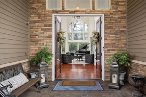 A grand entrance with a piano, a bench, and a welcome mat.