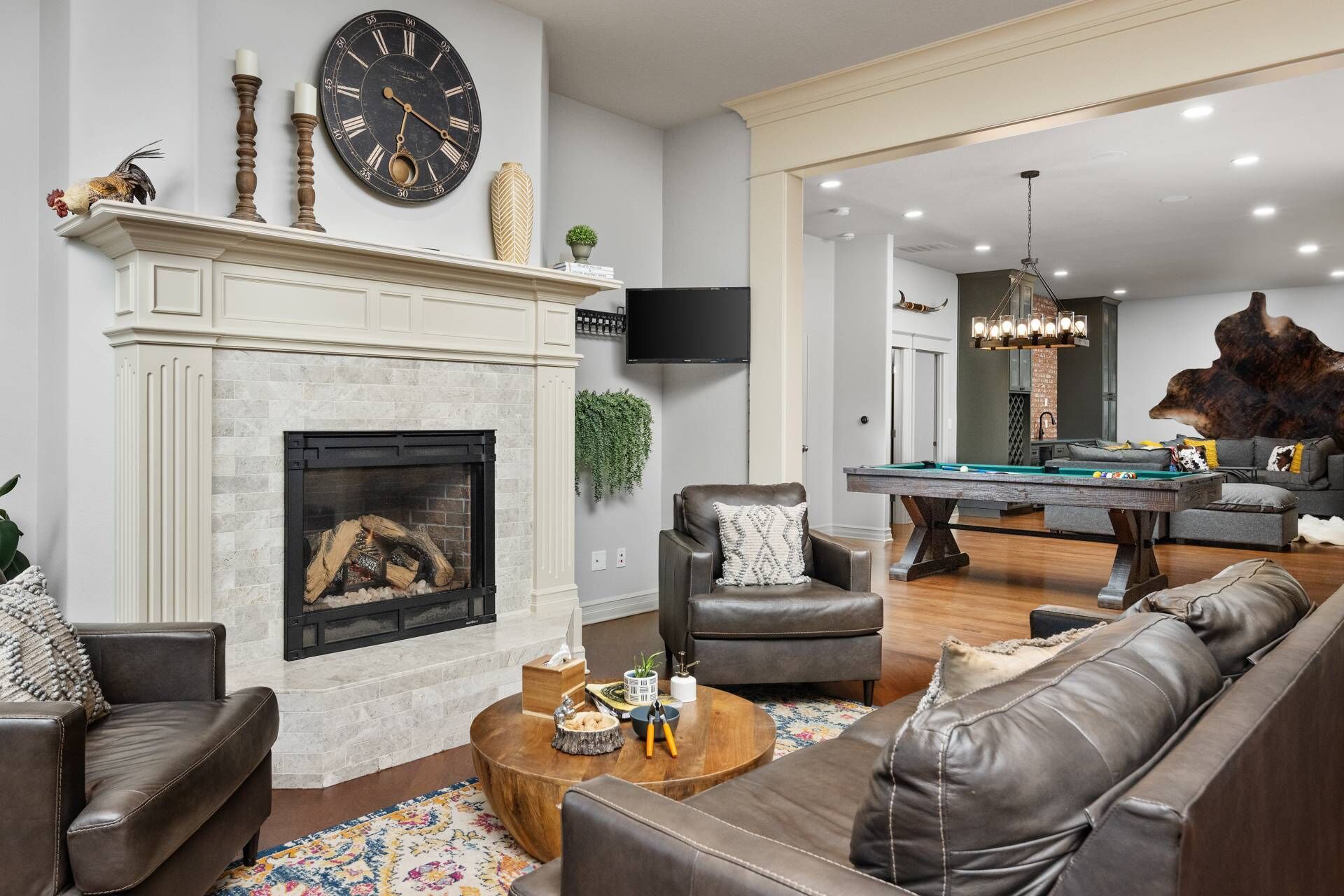 A living room with a fireplace, a pool table, and a billiards table.