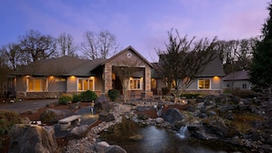 A stone house with a stone entrance and a small stream in the front yard. - Country Luxury in Manor, Pet Friendly, Hot Tub, Indoor Basketball Ct, Billiards, on 2 Acres (Newberg)