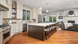 A spacious kitchen with a central island, wooden flooring, and modern appliances. - Country Luxury in Manor, Pet Friendly, Hot Tub, Indoor Basketball Ct, Billiards, on 2 Acres (Newberg)