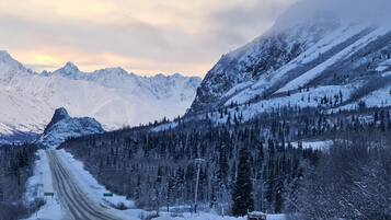 Una carretera de montaña cubierta de nieve bajo un cielo despejado.