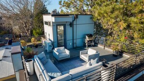 A rooftop deck with outdoor seating, a barbecue grill, and potted plants. - Luxe 3Bdr Home | Parking | Roof Oasis | City Views (Seattle)