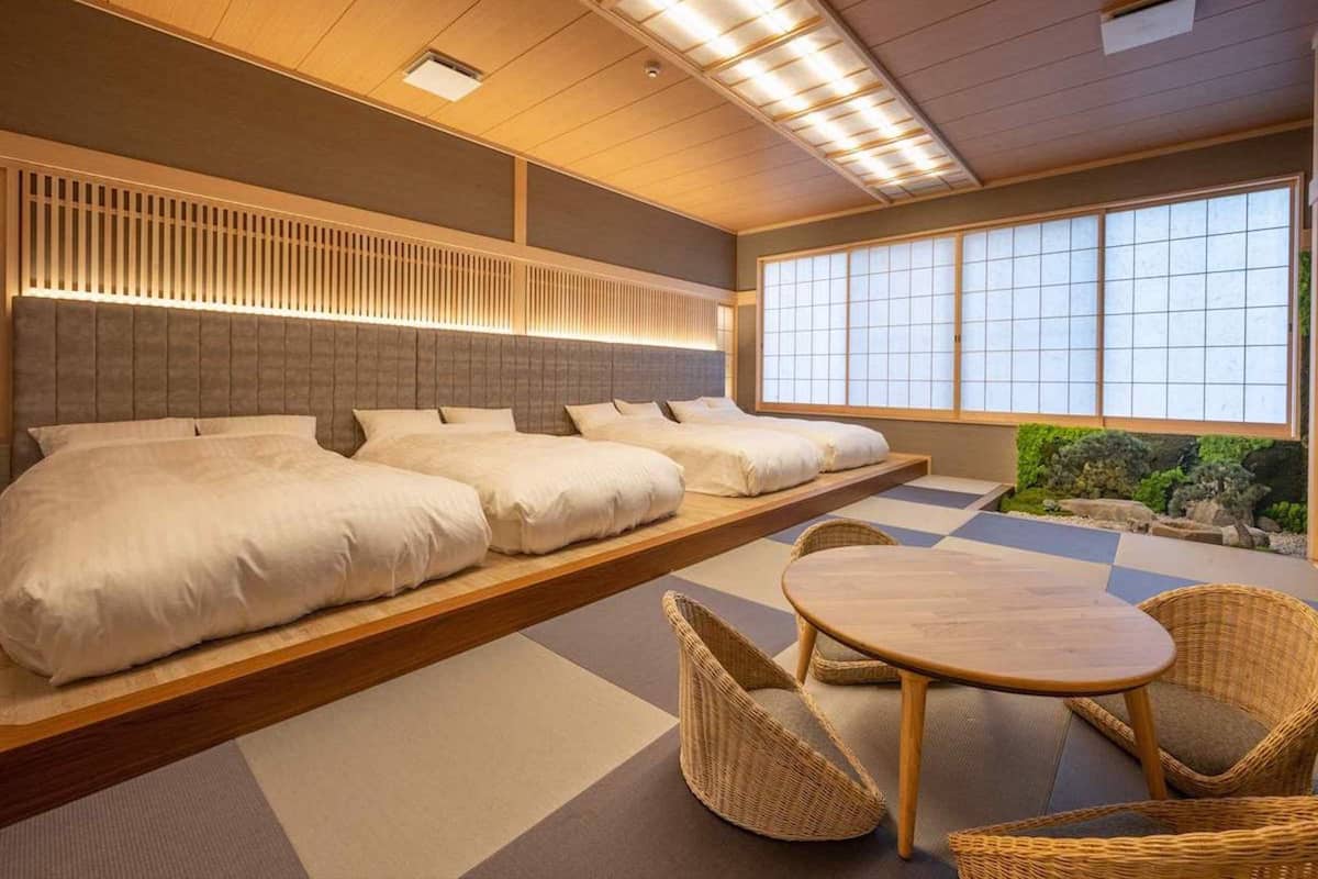 Une chambre d’hôtel moderne avec un grand lit, une petite table et des chaises.