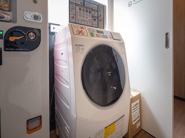 A front-loading washing machine with a control panel, a door, and a label indicating "WASH DRY".