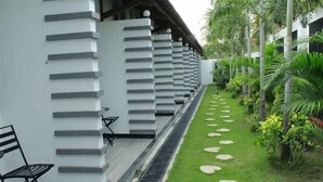 A modern building with a long, narrow corridor lined with white columns and benches. - Odaita Hotel (Pamekasan)