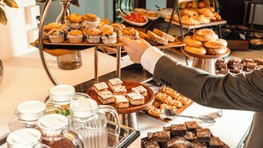 A buffet with various baked goods, including muffins, pastries, and brownies. - Soho Hotel Auckland (Auckland)