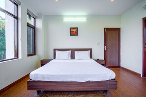 A modern bedroom with a large bed, wooden headboard, and a framed picture on the wall. - Kia Kasauli Chalet 3 BHK by Dumnu Homes (Krishangarh)