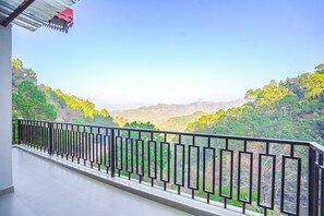 A balcony with a metal railing overlooking a mountainous landscape with dense greenery. - Kia Kasauli Chalet 3 BHK by Dumnu Homes (Krishangarh)