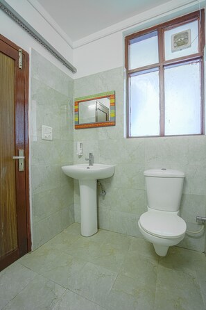 A bathroom with a sink, toilet, and a window with a view. - Kia Kasauli Chalet 3 BHK by Dumnu Homes (Krishangarh)