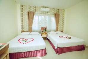 A hotel room with two beds, a nightstand with a lamp, and a window with curtains. - An Hotel by Zuzu (Can Tho Municipality)