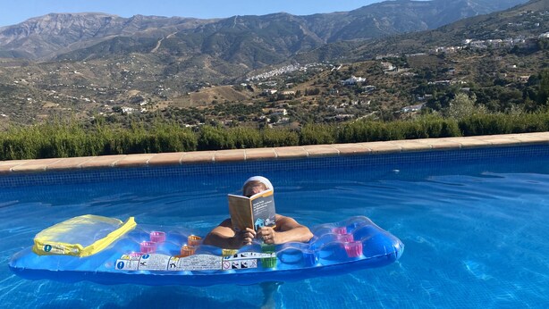A person floating in a pool with a mountain view in the background. - Beautiful holiday home in the heart of Andalucia, A/C, Private Pool, WiFi. (Cómpeta)