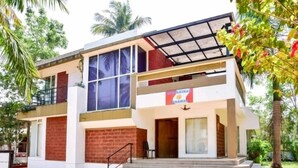A two-story building with a flat roof, large windows, and a sign indicating it is a school. - Surya Kiran Miramar (Panaji)