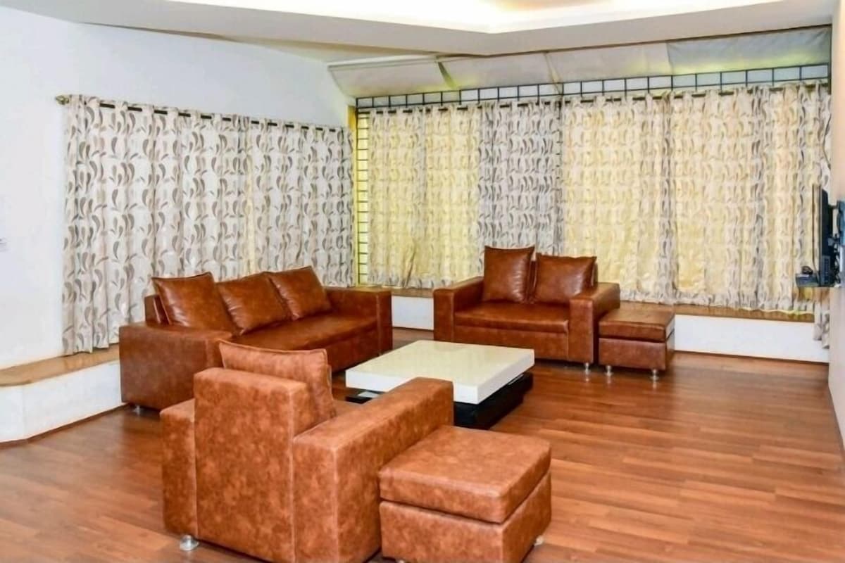 A living room with a brown sofa set, a coffee table, and a TV.