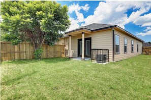 Stroll up to this charming home with a welcoming front porch and lush green surroundings.