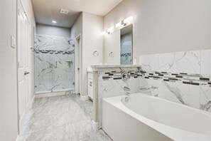 Enjoy a refreshing shower or unwind in the bathtub in this well-lit bathroom.