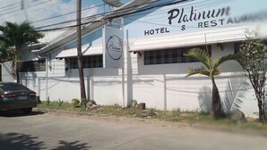 A building with a sign reading "Platinum Hotel & Restaurant" and a parked car. - Platinum Hotel (Angeles City)