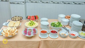 A buffet table with various food items and condiments. - Ximao Hotel Nha Trang by Zuzu (Nha Trang)