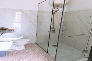 A bathroom with a glass-enclosed shower, a white sink, and a toilet. - Ximao Hotel Nha Trang by Zuzu (Nha Trang)