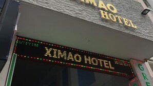The exterior of the Ximao Hotel with a prominent sign and a digital display.