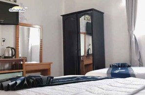 A hotel room with a bed, a desk, a wardrobe, and a mirror. - Ximao Hotel Nha Trang by Zuzu (Nha Trang)