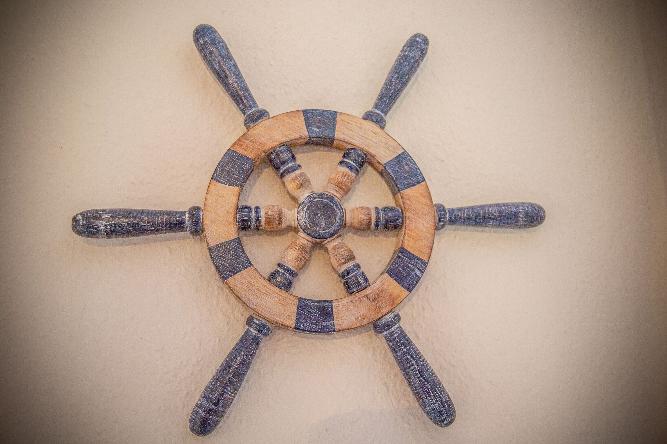 A wooden ship's wheel with eight spokes.