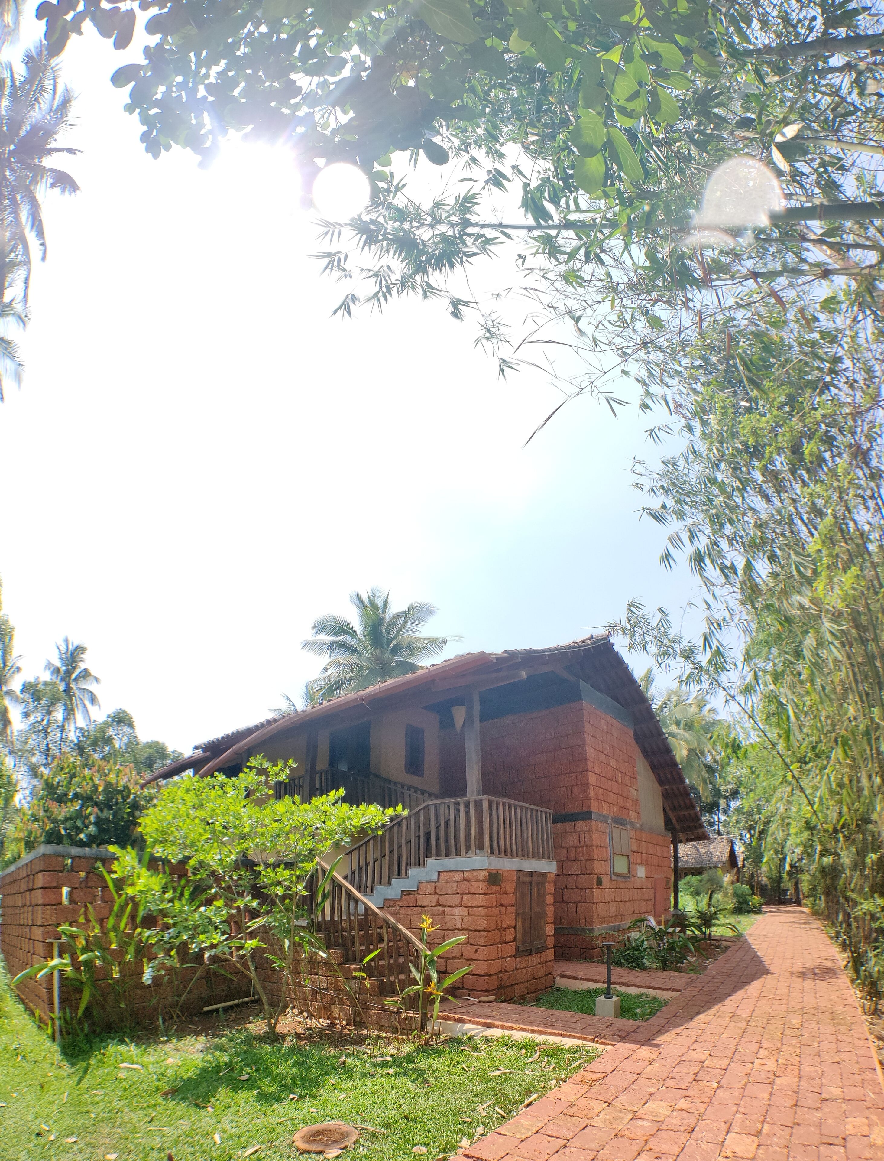 A brick house with a wooden staircase leading to a porch.