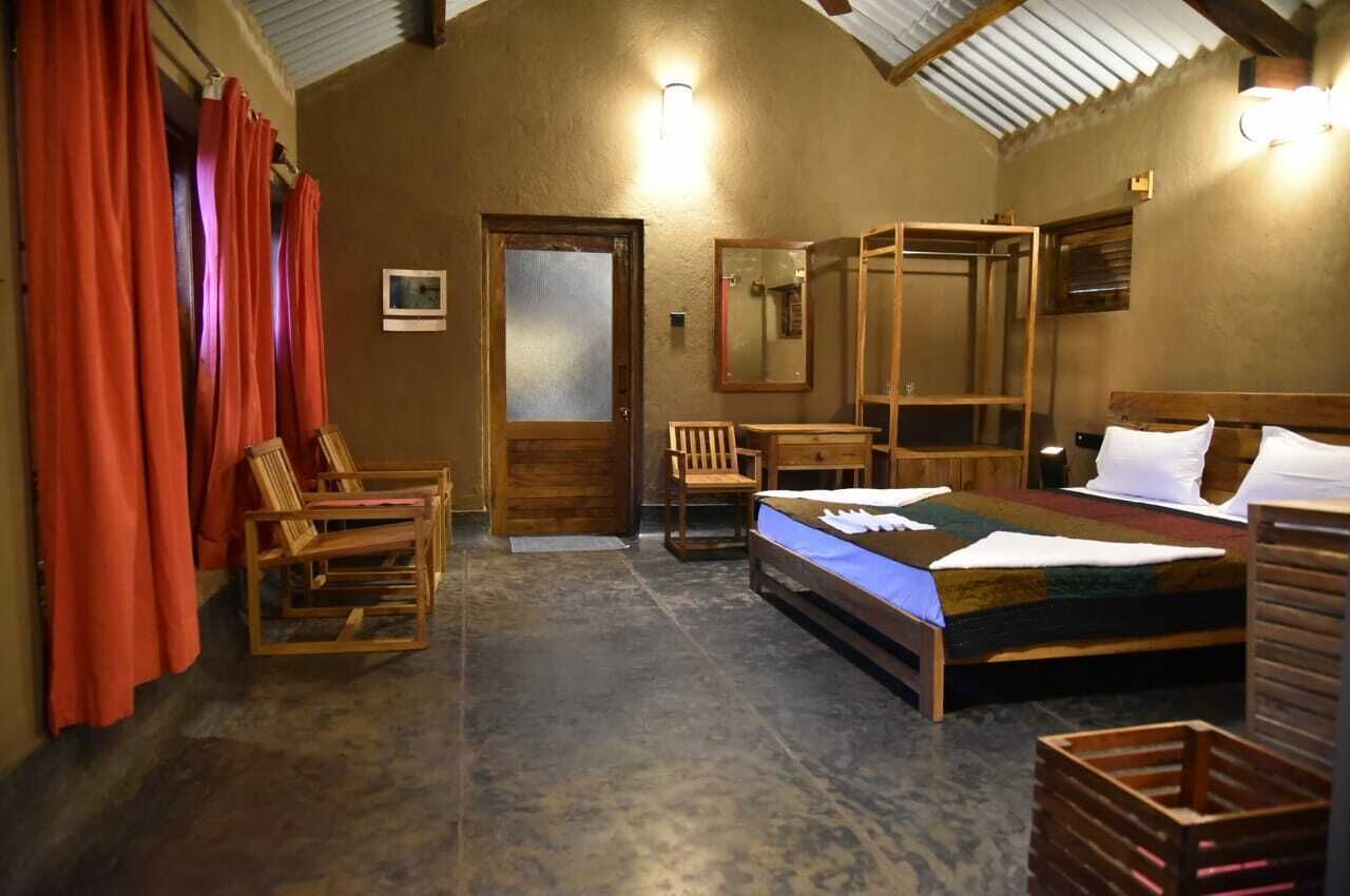 Una camera rustica con un letto, mobili in legno e uno specchio.