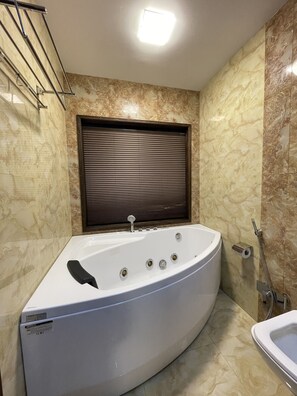 Ein modernes Badezimmer mit freistehender Badewanne, Toilette und Duschbereich.