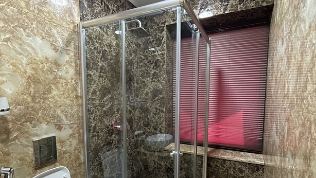 Ein Badezimmer mit einer Duschkabine, einer Toilette und einem Waschbecken.