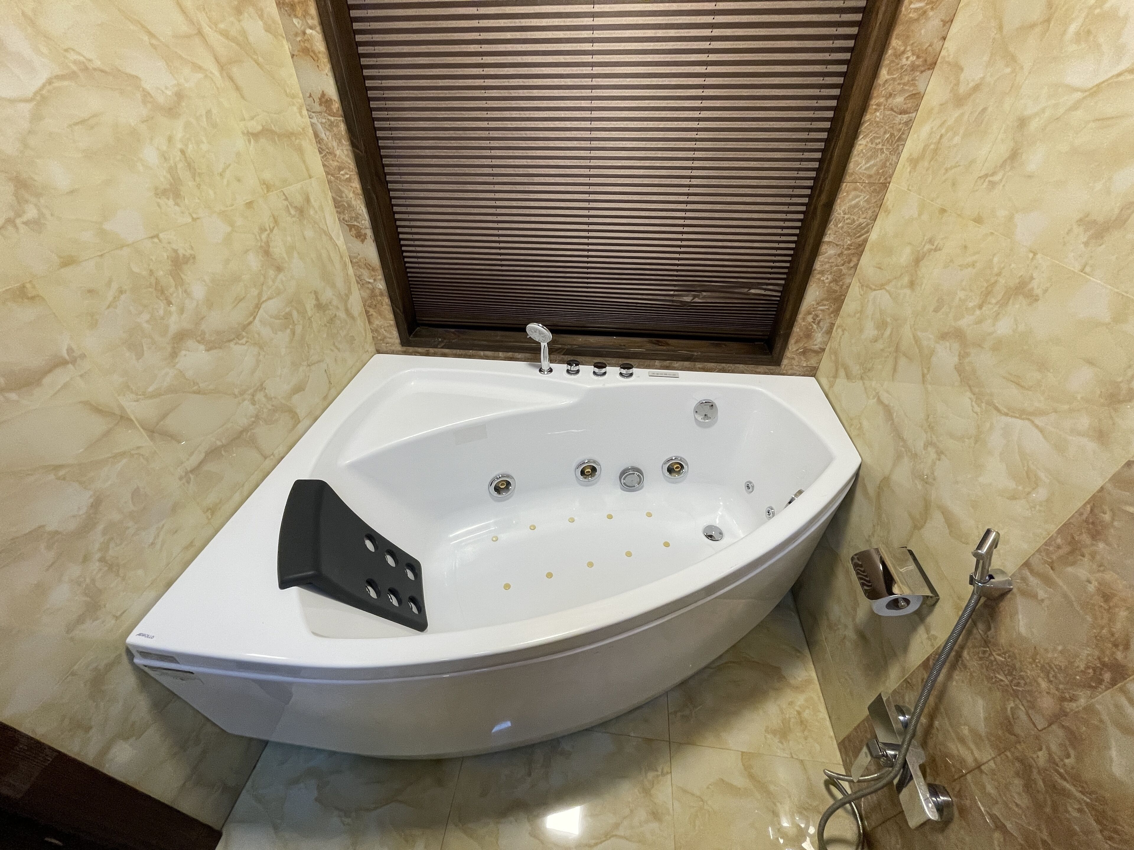 A modern bathroom with a freestanding bathtub, a handheld showerhead, and a built-in toilet.