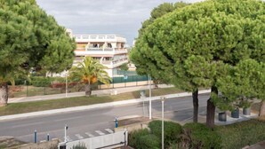 A modern building with a flat roof and a balcony, surrounded by well-maintained greenery and a clear road. - Escale Port by Interhome (Port Camargue)