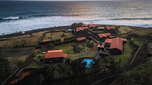 Ein Küstenresort mit mehreren Gebäuden, einem Swimmingpool und Blick aufs Meer.