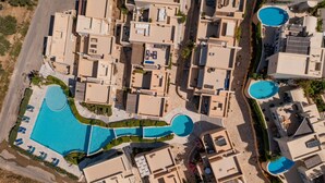 Eine Luftaufnahme eines Wohngebiets mit mehreren Gebäuden, einem großen zentralen Schwimmbecken und kleineren Becken.