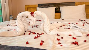 A bed with white linens, a wooden headboard, and pillows. - Life Artemis Otel (Izmir)
