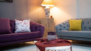 A living room with two sofas, a small table, and a lamp. - Life Artemis Otel (Izmir)