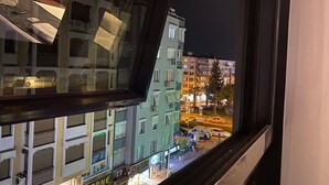 A nighttime view from a window overlooking a cityscape with buildings and a street. - Life Artemis Otel (Izmir)