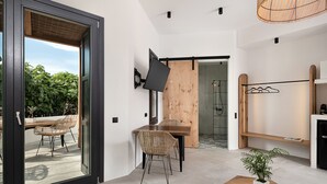 A modern interior with a dining area, a TV mounted on the wall, and a wooden door leading to another room.