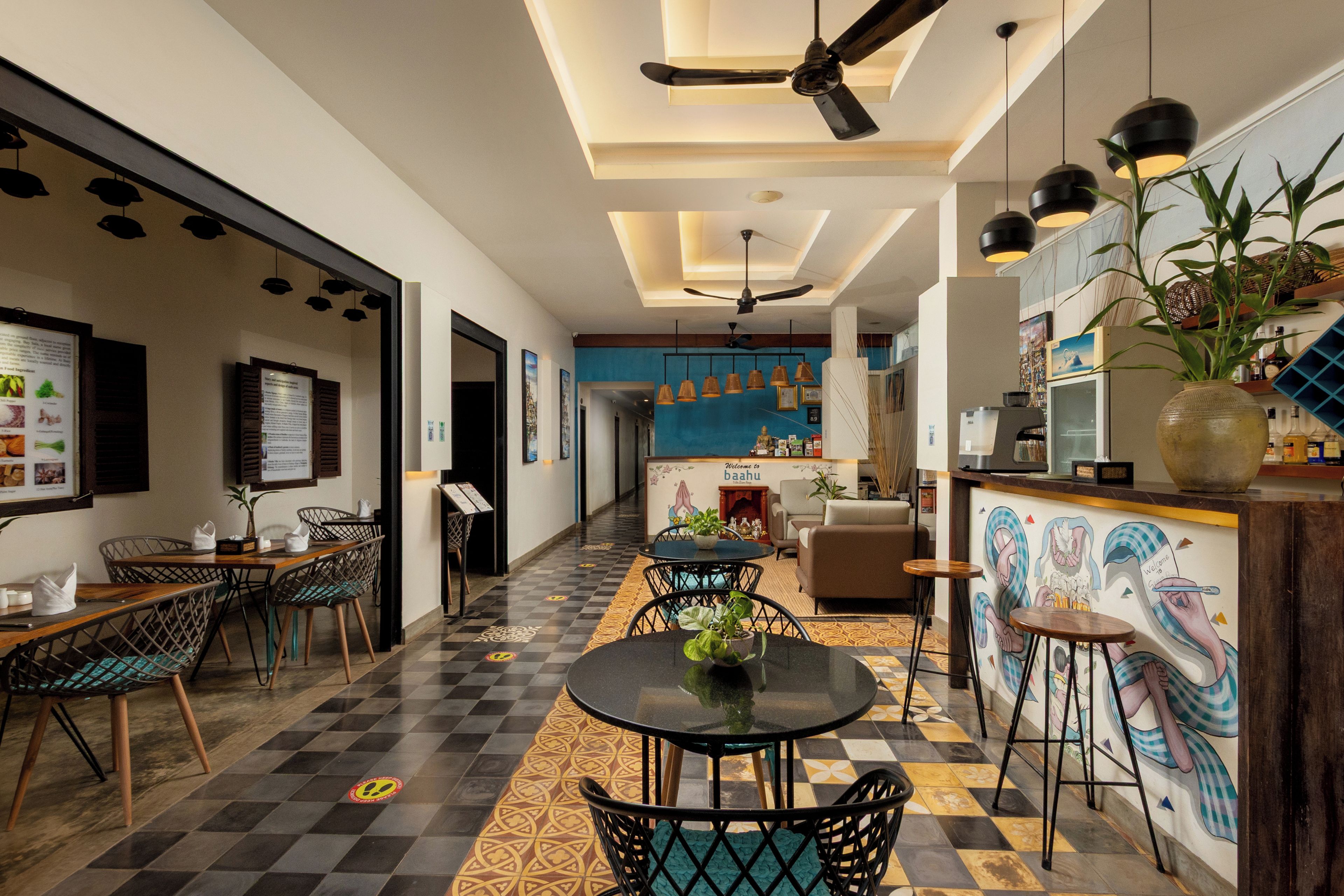 A modern interior with a checkered floor, a dining area with a round table, and a kitchen with a mural.