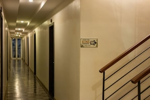 Passadís d'hotel amb un senyal a la paret que indica el camí als lavabos.