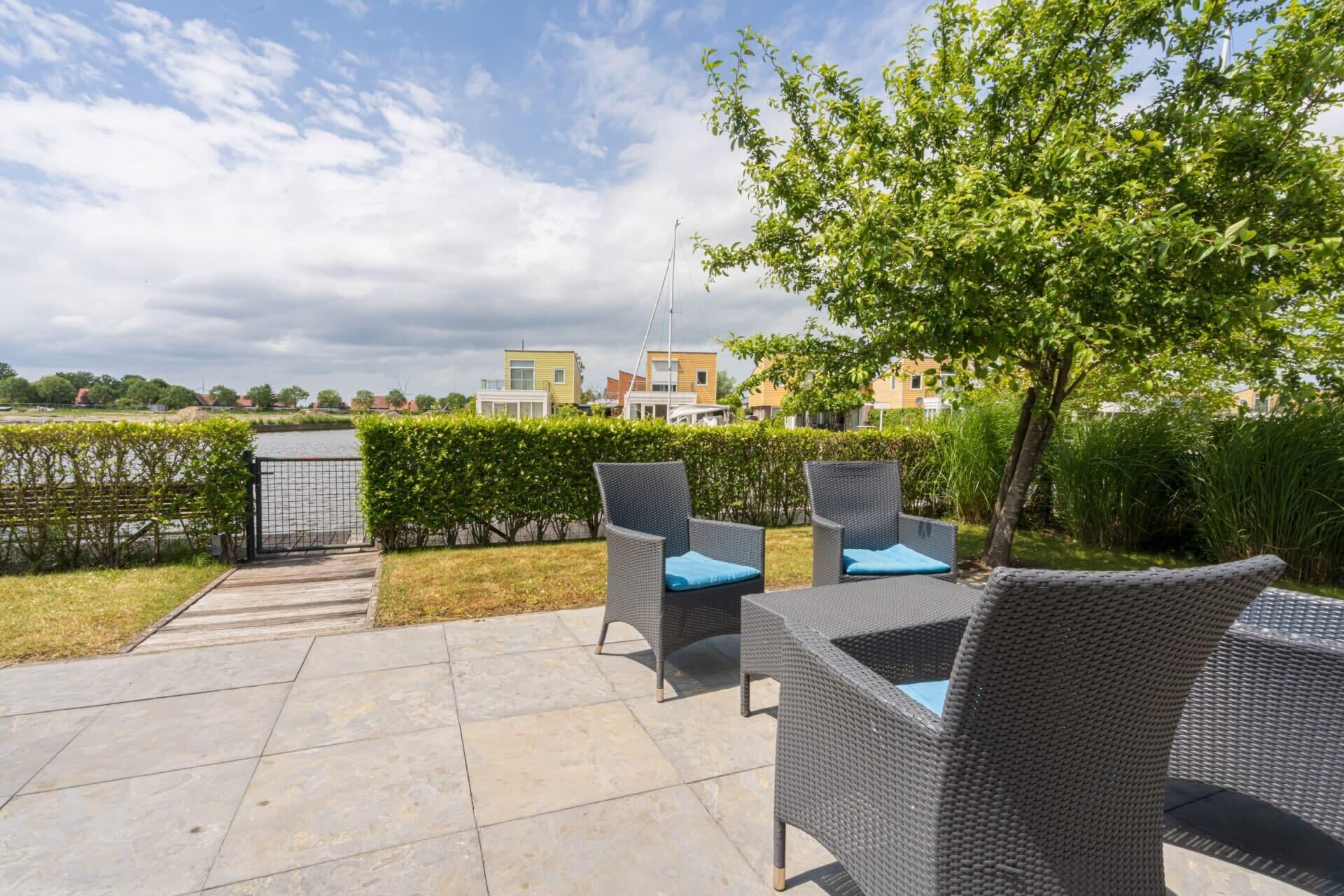 Un patio al aire libre con mobiliario de mimbre y vistas a edificios residenciales.