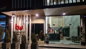 The exterior of a hotel with a modern design, featuring a prominent 'twin' sign and a reception area visible through the glass doors. - Thana Wisut Hotel (Bangkok)