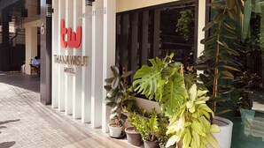 A hotel entrance with a modern design, featuring a prominent logo and the name 'THANAWISUT HOTEL'. - Thana Wisut Hotel (Bangkok)