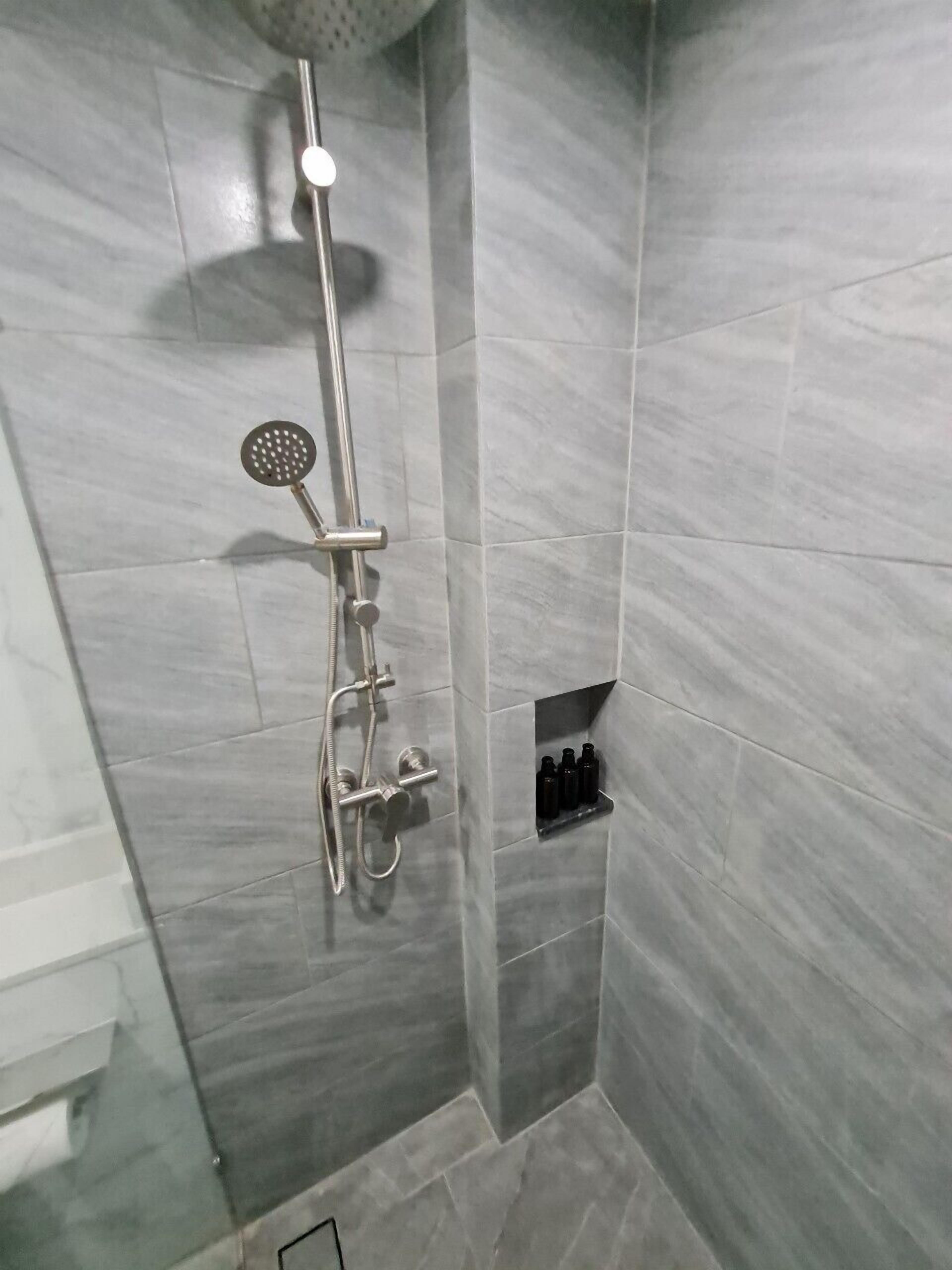 Ducha con cabezal de ducha de mano y grifo empotrado.